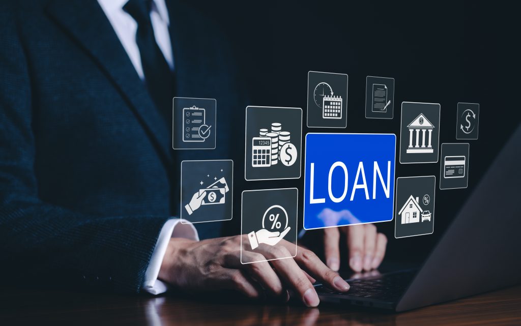 Hände auf einer Laptop-Tastatur, überlagert von digitalen Symbolen rund um das Thema Kreditvergabe, darunter das Wort „LOAN“ in Blau.
